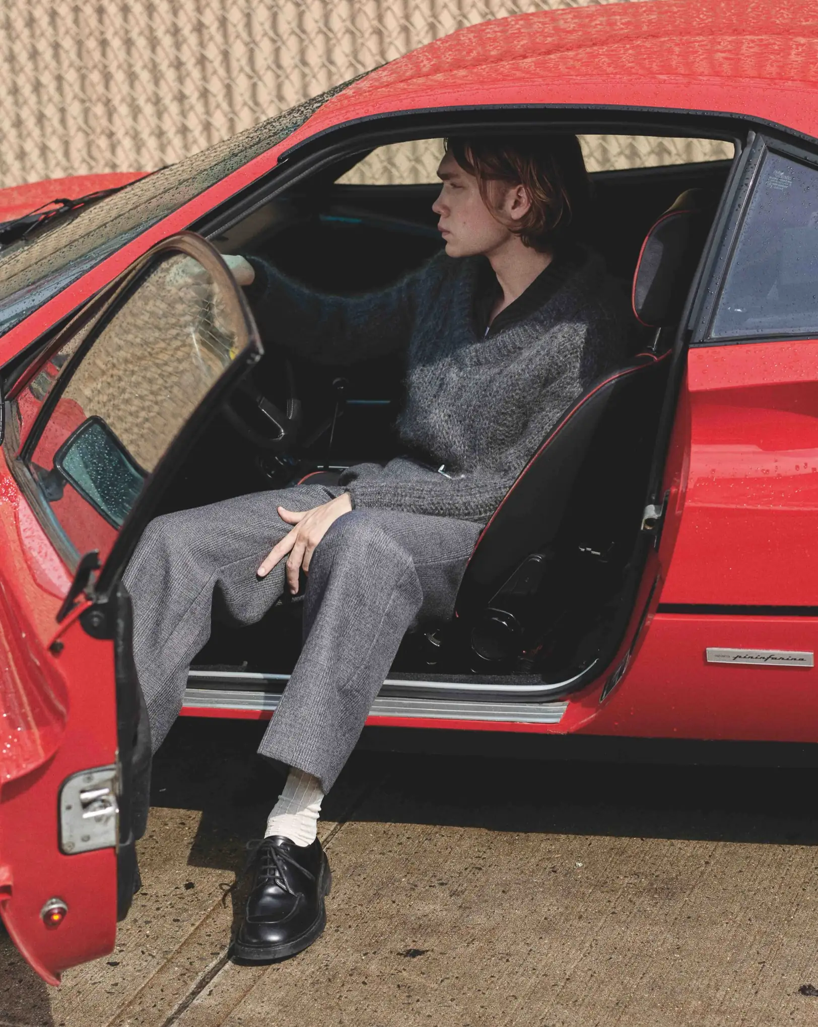 L'Officiel, 2021: a man in a grey suit sitting in a red sports car