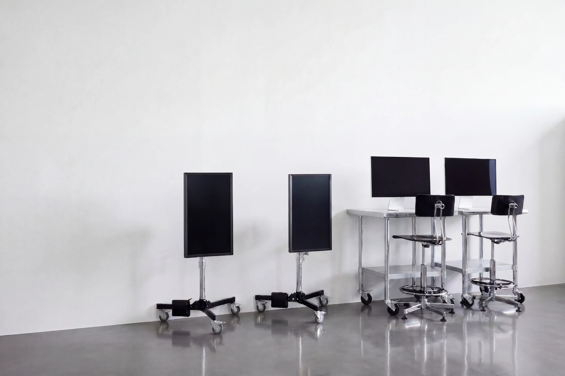Monitors on rolling stands in the white studio